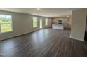 Open-concept living space with wood-look flooring, lots of natural light, and a view of the kitchen at 43 Chloe Ct, Selma, NC 27577