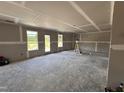 Large unfinished room featuring newly installed drywall and trim, windows and a sliding glass door at 43 Chloe Ct, Selma, NC 27577