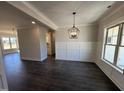 Elegant dining room with stylish chandelier, wainscoting, and dark hardwood flooring at 47 Royal Ave, Selma, NC 27576