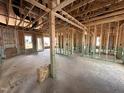 Unfinished interior of a new build showing wood framing, unfinished floors, and windows with natural light at 47 Royal Ave, Selma, NC 27576