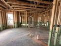 Unfinished interior of a new build showing wood framing, unfinished floors and a door frame leaning against the wall at 47 Royal Ave, Selma, NC 27576