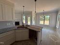 Kitchen featuring granite countertops, stainless sink and stylish lighting fixtures in an open layout at 47 Royal Ave, Selma, NC 27576