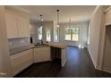 Modern kitchen with white cabinets, granite countertops, and dark hardwood flooring at 47 Royal Ave, Selma, NC 27576