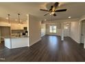 Open-concept living space showcasing hardwood floors, wainscoting, natural light, and views of the kitchen at 47 Royal Ave, Selma, NC 27576