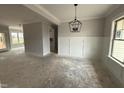 Bright, open living space with wainscoting and modern chandelier, awaiting your personal touch at 47 Royal Ave, Selma, NC 27576