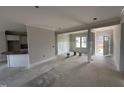 Living room with white trim, neutral paint, and an adjacent kitchen and entry at 47 Royal Ave, Selma, NC 27576