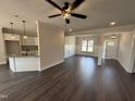 Open-concept living space with wood floors, connecting the kitchen and dining areas at 47 Royal Ave, Selma, NC 27576