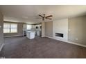 Open concept living room with hardwood floors, white cabinets, kitchen island and white fireplace at 48 Silver Ct, Smithfield, NC 27577