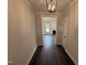 A home hallway with dark hardwood floors and a view into the living room with white trim and fireplace at 56 Bailey-Boykin Rd, Selma, NC 27576