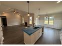 A kitchen with white cabinets, stainless appliances, an island sink, and a view into the living room at 56 Bailey-Boykin Rd, Selma, NC 27576