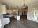 Modern kitchen with white cabinetry, center island, and pendant lighting at 56 Bailey-Boykin Rd, Selma, NC 27576