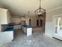 Bright kitchen with white cabinets, an island with a sink, and modern pendant lighting at 56 Bailey-Boykin Rd, Selma, NC 27576