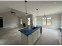 Open-concept kitchen island with sink, view to fireplace and living area in a bright open floor plan at 56 Bailey-Boykin Rd, Selma, NC 27576