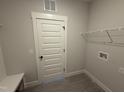 Laundry room featuring tile floors, a white door, and a white wire storage shelf at 56 Bailey-Boykin Rd, Selma, NC 27576