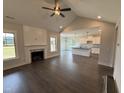 Open-concept living room with a fireplace, modern ceiling fan, and view to the kitchen with island at 56 Bailey-Boykin Rd, Selma, NC 27576