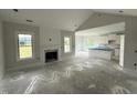 Bright and airy living space with fireplace, large windows, and open access to the modern kitchen with a kitchen island at 56 Bailey-Boykin Rd, Selma, NC 27576
