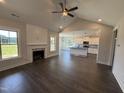 Open-concept living room with fireplace, island, vaulted ceilings, and lots of light at 56 Bailey-Boykin Rd, Selma, NC 27576
