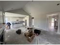 Open-concept living room and kitchen with white cabinets and a vaulted ceiling under construction at 56 Bailey-Boykin Rd, Selma, NC 27576