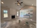 Open concept living room with a fireplace, shiplap accents, and vaulted ceilings with fan at 56 Bailey-Boykin Rd, Selma, NC 27576