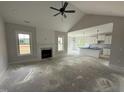 Bright living room featuring vaulted ceiling, shiplap fireplace, and seamless transition to kitchen with modern fixtures at 56 Bailey-Boykin Rd, Selma, NC 27576