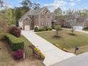 Beautifully landscaped yard with long driveway leading to a brick two-story house with an attached two-car garage at 5928 Terrington Ln, Raleigh, NC 27606