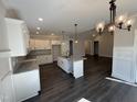 Modern kitchen featuring white cabinets, granite countertops, stainless steel appliances, and an island with a sink at 612 Tuscany Cir, Princeton, NC 27569