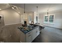 Well-lit kitchen with open floor plan, island sink, and decorative lighting fixtures at 612 Tuscany Cir, Princeton, NC 27569