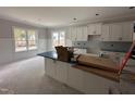 Modern kitchen features white cabinets, subway tile backsplash, and a large island with stylish countertop at 612 Tuscany Cir, Princeton, NC 27569