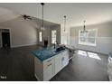 Modern kitchen featuring a center island, pendant lighting, white cabinets, and an open layout at 612 Tuscany Cir, Princeton, NC 27569