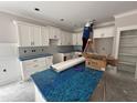 Well-lit kitchen with white cabinets, new appliances and an island, blending functionality with contemporary style at 612 Tuscany Cir, Princeton, NC 27569