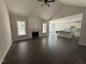 An open-concept living room with a fireplace, hardwood floors, and bright windows at 612 Tuscany Cir, Princeton, NC 27569