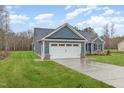 Side view of a home showcasing a pristine two-car garage, manicured lawn, and inviting curb appeal at 613 Tuscany Cir, Princeton, NC 27569