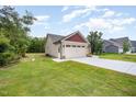 View of a large two-car garage with an extended driveway and a well-kept lawn at 702 Tuscany Cir, Princeton, NC 27569