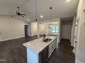 Stylish kitchen island with granite countertops, pendant lighting, and stainless steel appliances, perfect for entertaining at 702 Tuscany Cir, Princeton, NC 27569