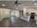 Bright, open-concept living space with a modern kitchen island and stainless appliances, seamlessly connecting to the dining area at 702 Tuscany Cir, Princeton, NC 27569