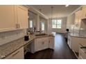 Modern kitchen with granite countertops, white cabinets, and stainless steel sink at 71 Royal Ave, Selma, NC 27576