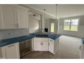 Kitchen island features a stainless sink, white cabinetry, and views of the fireplace at 71 Royal Ave, Selma, NC 27576