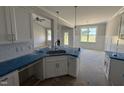 Modern kitchen with white cabinets and a large island, flowing into the living and dining spaces at 71 Royal Ave, Selma, NC 27576