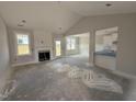 Open-concept living room with fireplace, wainscoting, and plenty of natural light at 71 Royal Ave, Selma, NC 27576