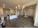 Open concept living room and kitchen featuring hardwood floors and modern lighting at 71 Royal Ave, Selma, NC 27576
