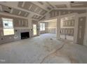 Unfinished living room showcasing a cozy fireplace, with large windows providing ample natural light at 71 Royal Ave, Selma, NC 27576