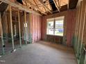Unfinished room with insulated walls and a large window featuring views of the outside neighborhood at 71 Royal Ave, Selma, NC 27576