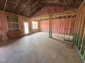 Unfinished living room featuring insulated walls, a back door, and windows framing the partially-built home at 71 Royal Ave, Selma, NC 27576