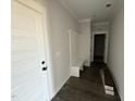 Hallway featuring wood floors, a coat rack bench and white trim at 76 Royal Ave, Selma, NC 27576