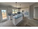 A kitchen with white cabinets, stainless steel appliances, an island, and pendant lighting at 76 Royal Ave, Selma, NC 27576