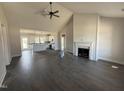 Bright living room with wood floors, fireplace, ceiling fan, and open to the kitchen at 76 Royal Ave, Selma, NC 27576