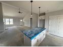 Open-concept living space featuring kitchen island, living room, and foyer with a vaulted ceiling at 76 Royal Ave, Selma, NC 27576