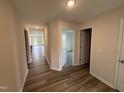 Bright hallway with hardwood floors and doorways to various rooms at 8 W Emily Gardens Dr, Selma, NC 27576