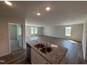 Bright, open-concept kitchen with granite countertops, stainless steel appliances, and views of the living area at 8 W Emily Gardens Dr, Selma, NC 27576