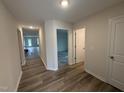 Hallway with wood-look flooring, and white doors leading to various rooms within the house at 8 W Emily Gardens Dr, Selma, NC 27577
